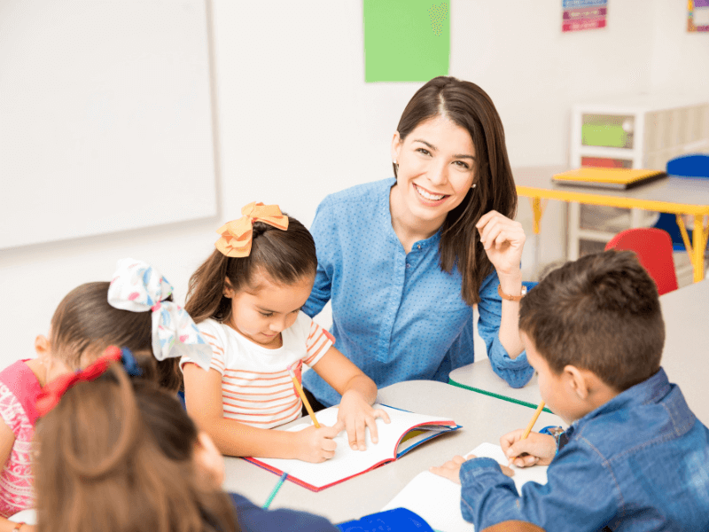 Professora branca ensinando crianças em uma escola