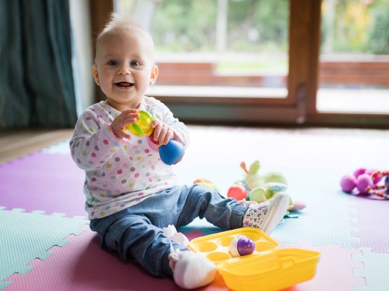 Bebê sorrindo e brincando com brinquedos