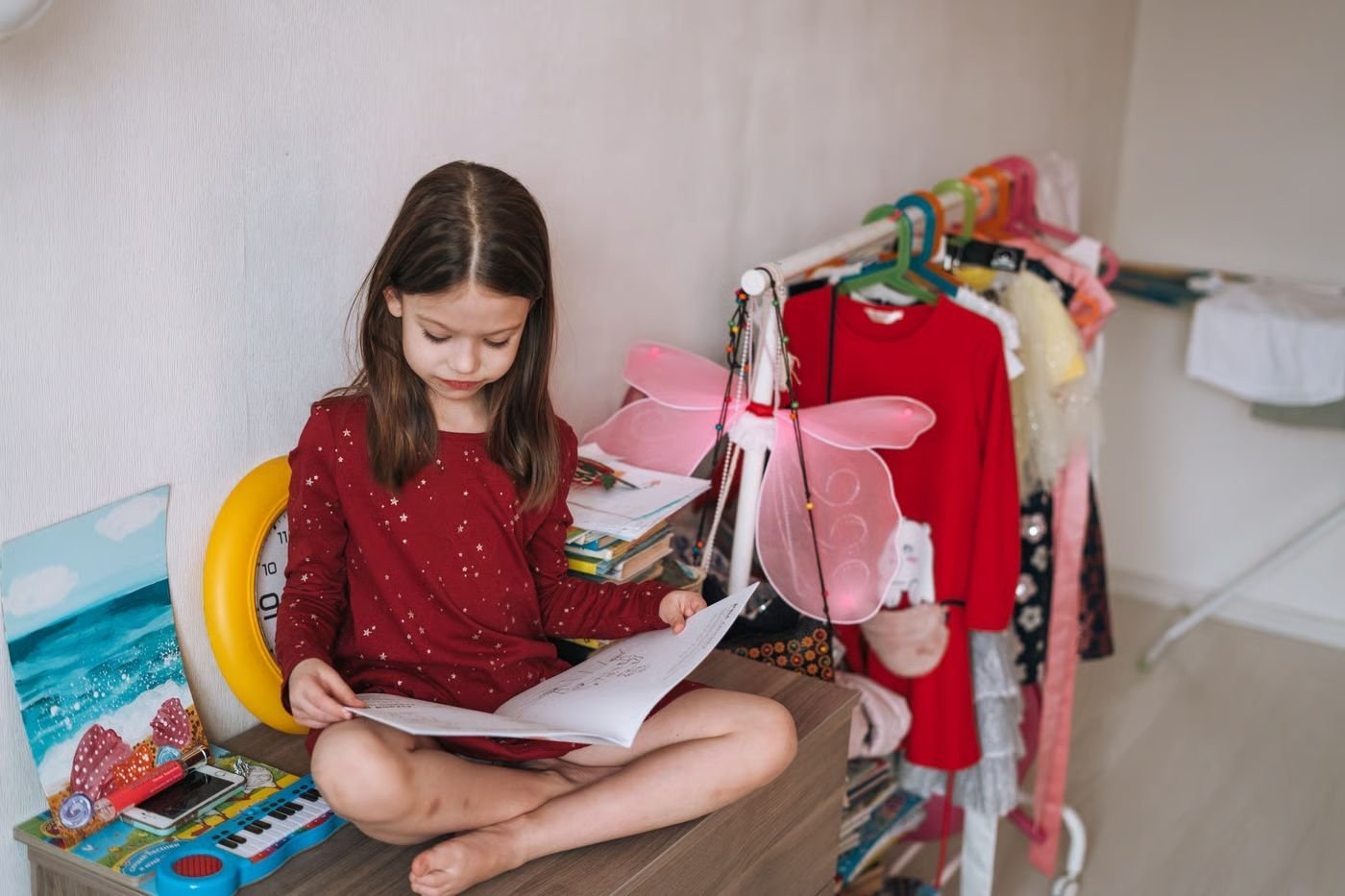 Criança brincando com brinquedos e acessórios em um ambiente infantil, explorando diferentes possibilidades durante uma atividade lúdica.