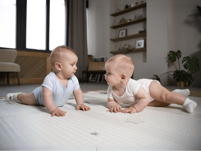 Dois bebês brancos de frente um pro outro e conversando