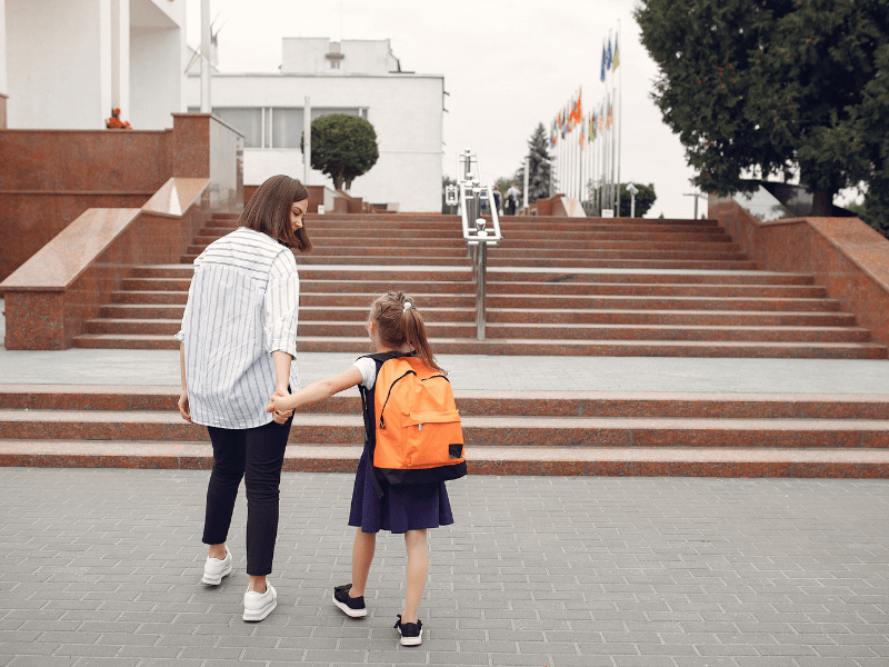 Uma mãe levando sua filha para a escola
